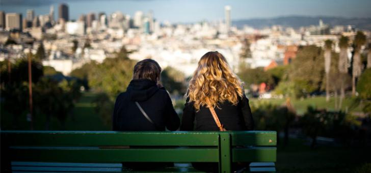 women sitting on a park bench